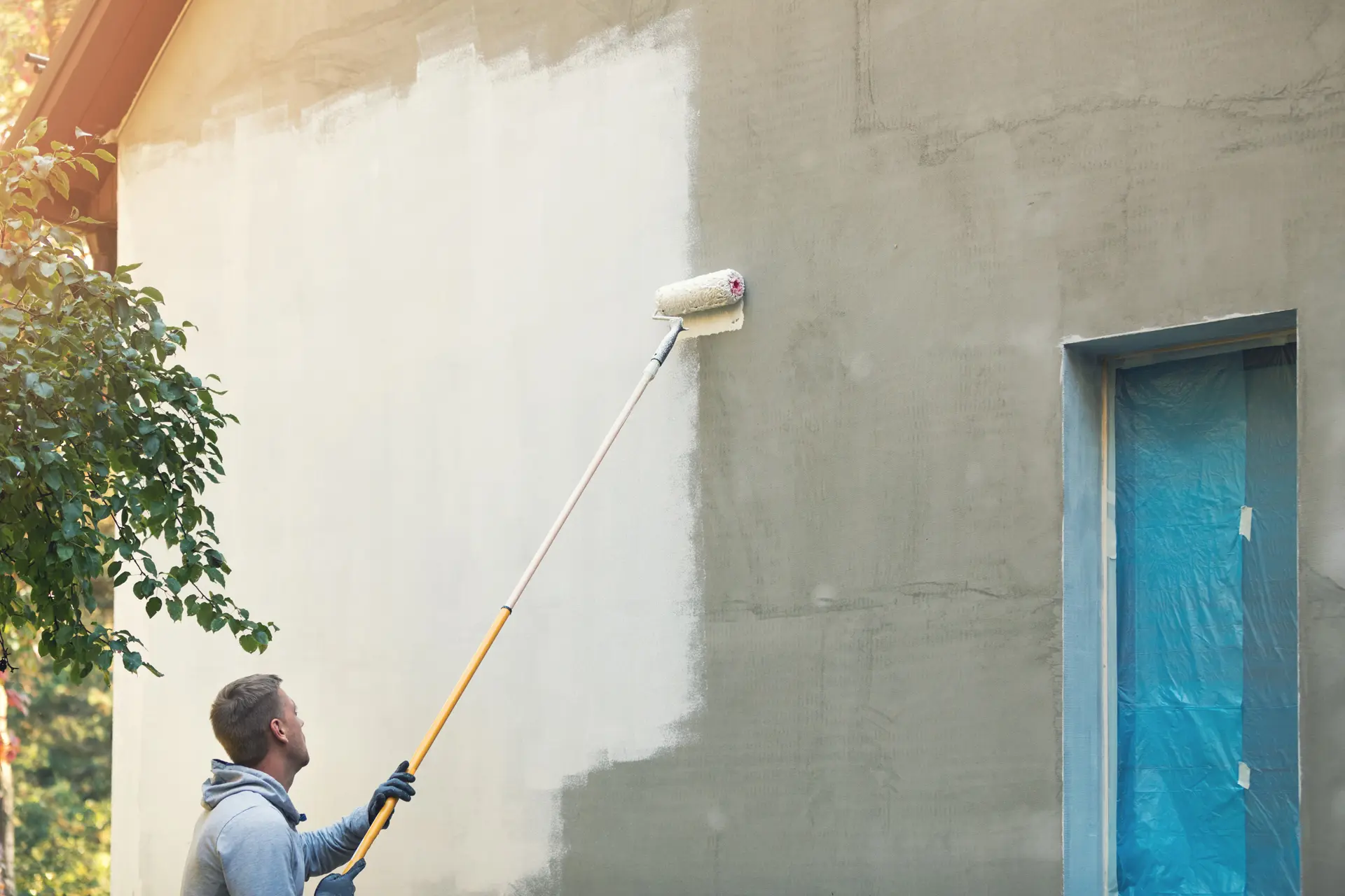 Pintor trabajando en una fachada en Cornellà